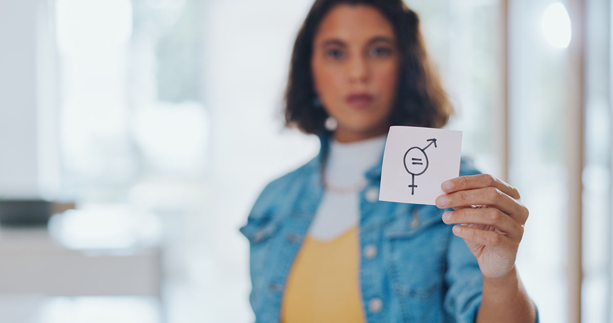 Mujer joven con un papel con el símbolo de igualdad de género. 